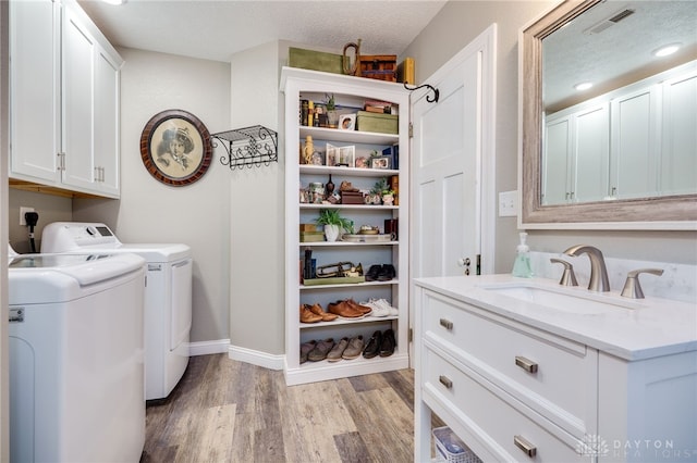 65 N Central Ave, Fairborn, OH 45324 - washroom featuring cabinet space, light wood-style floors, washing machine and clothes dryer, and a textured ceiling