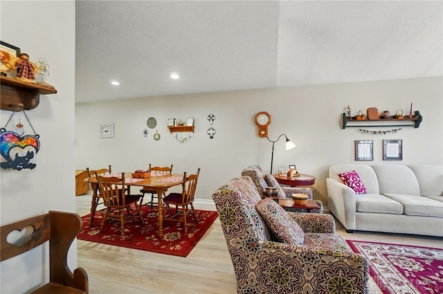 dining room with light wood-type flooring, recessed lighting, a textured ceiling, and baseboards