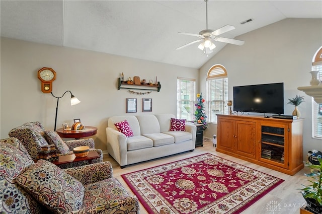 living room with light wood finished floors, a ceiling fan, and high vaulted ceiling