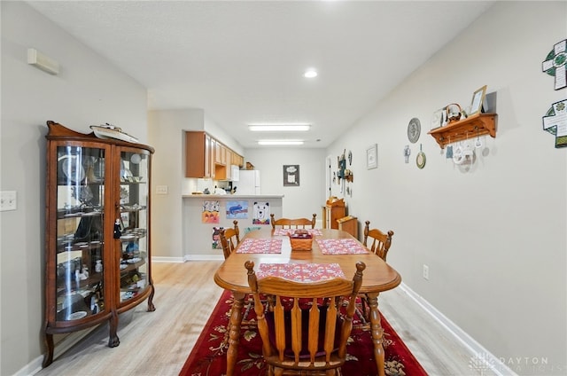 dining space featuring light wood-type flooring, baseboards, and recessed lighting