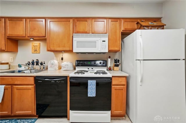 kitchen featuring white appliances, a sink, light countertops, and brown cabinetry