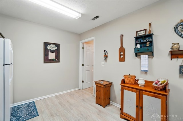hall with light wood finished floors and baseboards
