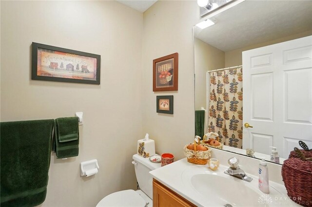 full bathroom with toilet, vanity, and curtained shower