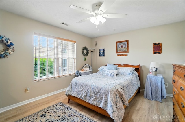 bedroom featuring light wood finished floors, baseboards, and ceiling fan