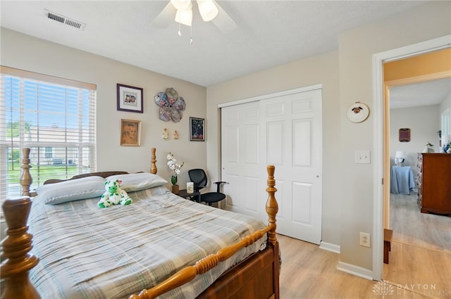 bedroom with light wood-style floors, a closet, baseboards, and a ceiling fan