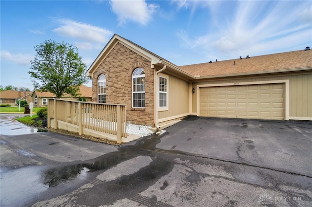 view of front of property with asphalt driveway, a garage, and brick siding