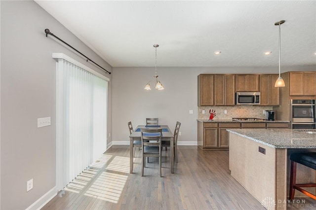 3631 Capitol Ave, Mason, OH 45040 - kitchen with appliances with stainless steel finishes, brown cabinets, tasteful backsplash, light wood finished floors, and recessed lighting