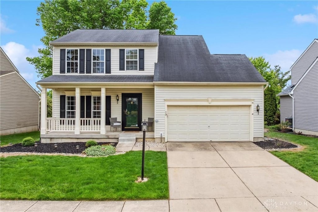 13 Christman Dr, Springboro, OH 45066 - view of front of property with a porch, an attached garage, a front lawn, and driveway