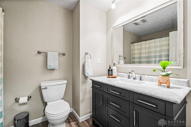 full bath with wood finished floors, a textured ceiling, toilet, vanity, and baseboards