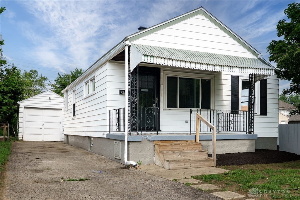 2121 S Smithville Rd, Dayton, OH 45420 - view of front of property featuring an outdoor structure, concrete driveway, crawl space, a garage, and covered porch