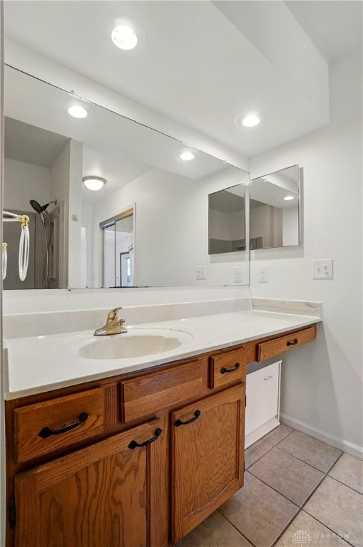 bathroom with vanity, tile patterned floors, baseboards, and recessed lighting