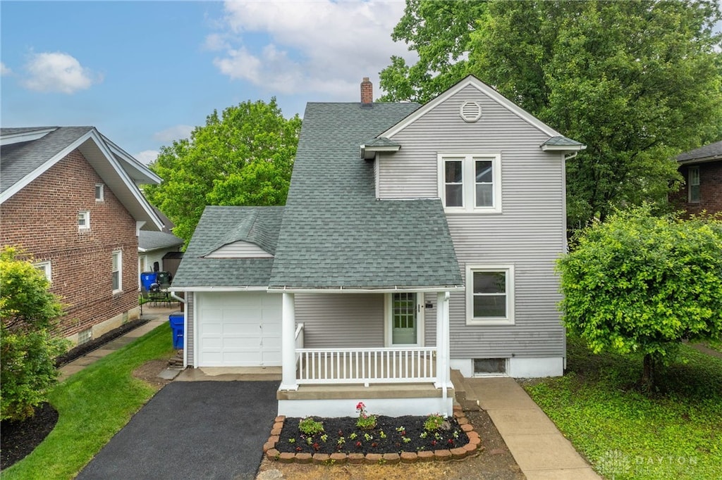 635 Haven Ave, Hamilton, OH 45013 - traditional-style home with an attached garage, roof with shingles, covered porch, a chimney, and driveway