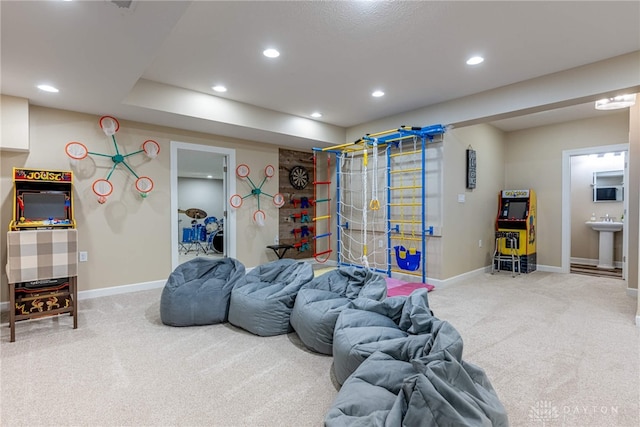 recreation room with carpet flooring, baseboards, recessed lighting, and a sink
