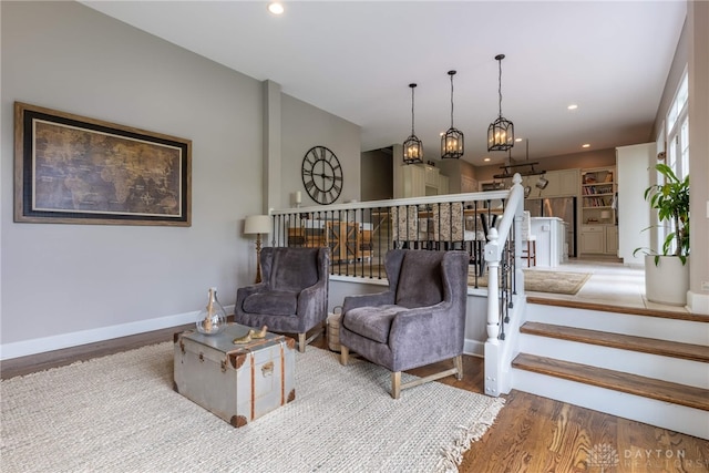 living room featuring wood finished floors, recessed lighting, baseboards, and stairway