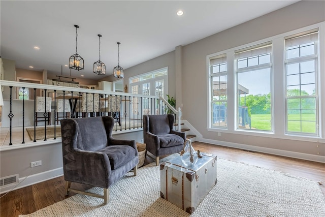 living area featuring baseboards, wood finished floors, recessed lighting, and stairs
