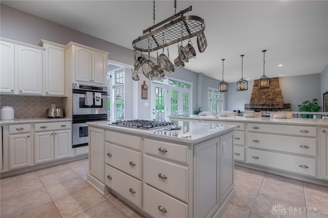 kitchen featuring appliances with stainless steel finishes, a kitchen island, tasteful backsplash, light countertops, and recessed lighting