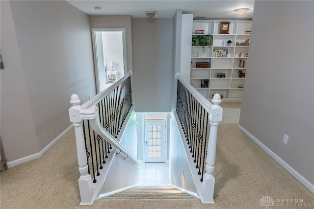 stairway featuring carpet flooring and baseboards