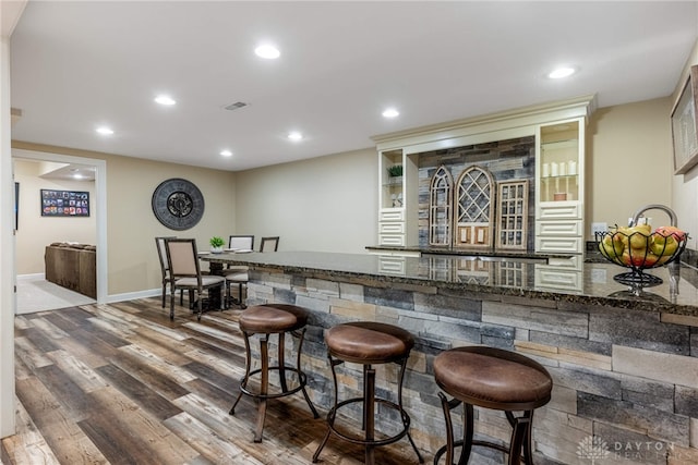 indoor bar featuring wood finished floors, recessed lighting, and baseboards