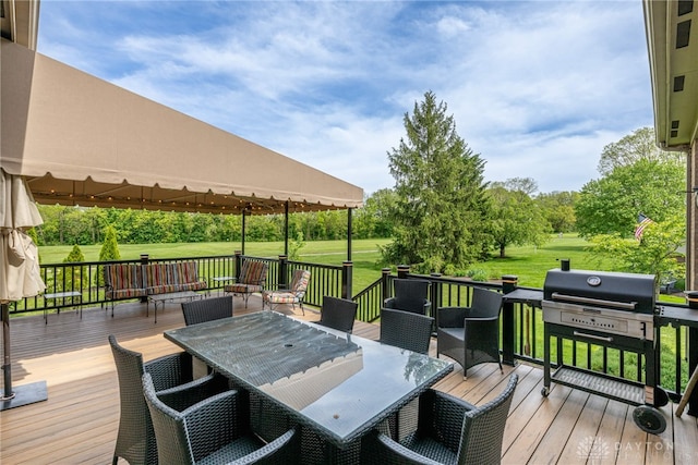 wooden terrace with outdoor dining space, a lawn, and a gazebo