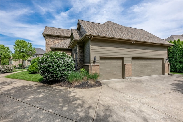 view of property exterior featuring concrete driveway, a garage, a shingled roof, and brick siding