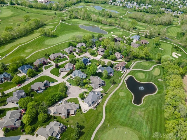 view of property location featuring a nearby body of water, nearby suburban area, and a golf course