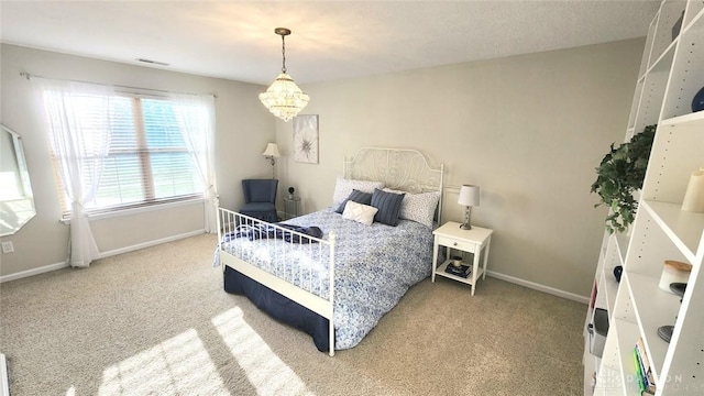 carpeted bedroom featuring baseboards and a chandelier