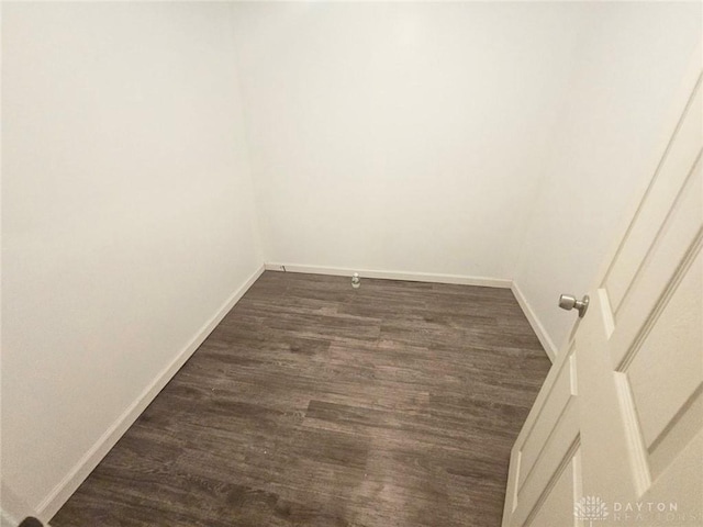 unfurnished room with dark wood finished floors and baseboards