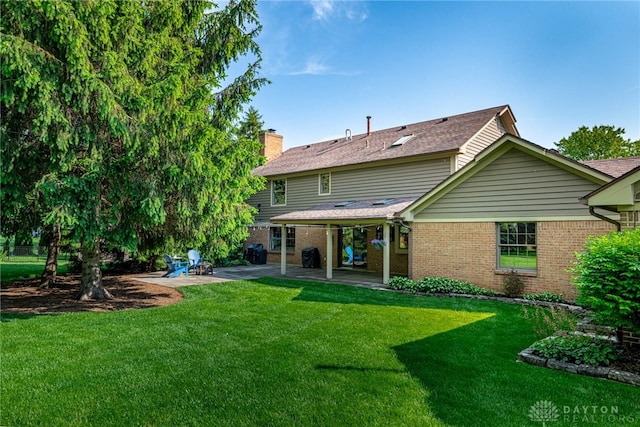 2100 Hunters Bluff Ct, Washington Twp, OH 45458 - rear view of property featuring a patio area, a chimney, brick siding, a lawn, and a shingled roof