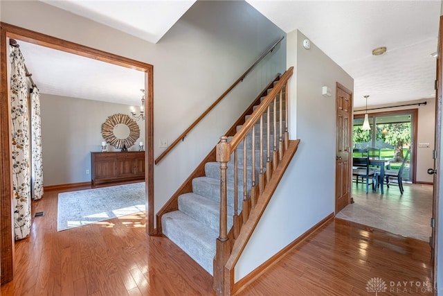 2100 Hunters Bluff Ct, Washington Twp, OH 45458 - stairs featuring wood finished floors, baseboards, and a chandelier