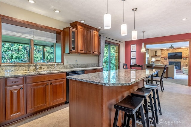 2100 Hunters Bluff Ct, Washington Twp, OH 45458 - kitchen with dishwasher, a sink, light stone countertops, brown cabinetry, and a breakfast bar area