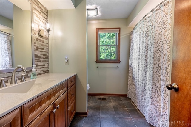 2100 Hunters Bluff Ct, Washington Twp, OH 45458 - bathroom with decorative backsplash, baseboards, vanity, toilet, and tile patterned floors