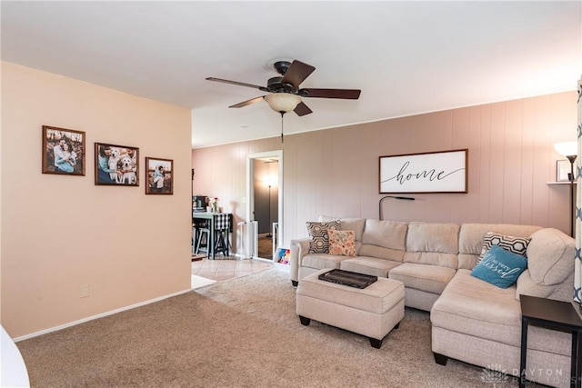 carpeted living room featuring ceiling fan and baseboards