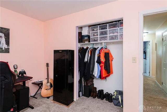 carpeted bedroom featuring a desk and a closet