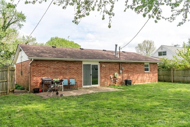 rear view of property featuring central AC, brick siding, and a patio