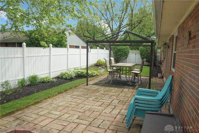 view of patio / terrace with a gazebo, outdoor dining area, and a fenced backyard