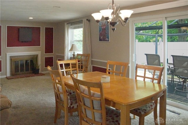 dining space featuring a chandelier, a glass covered fireplace, recessed lighting, and baseboards