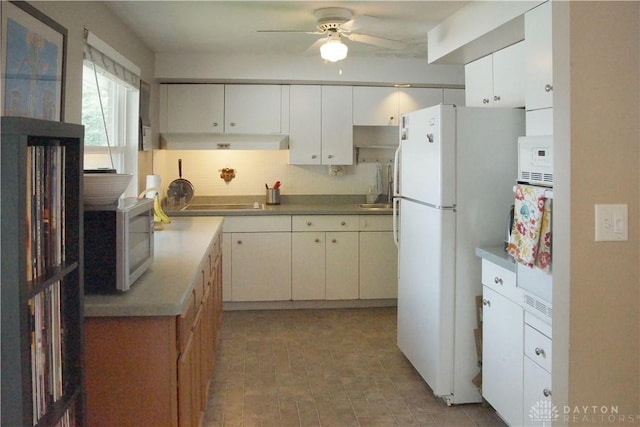 kitchen featuring white appliances, under cabinet range hood, ceiling fan, tasteful backsplash, and white cabinetry