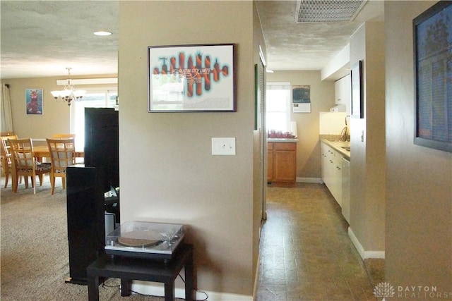 corridor featuring a chandelier and baseboards
