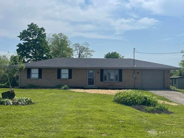 single story home with a garage, driveway, a front lawn, and brick siding