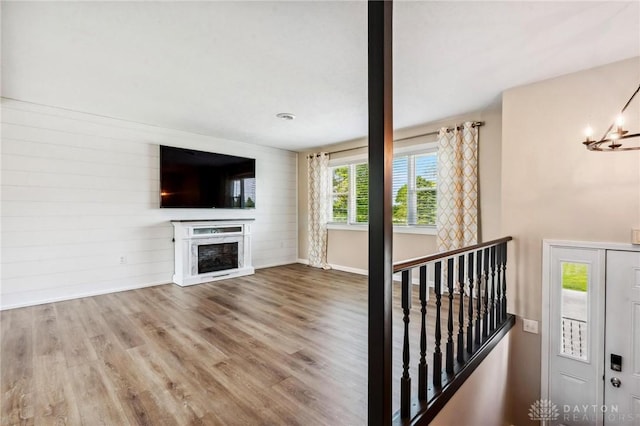 7217 State Route 380, Chester Twp, OH 45177 - unfurnished living room featuring wood finished floors, baseboards, a chandelier, and a fireplace