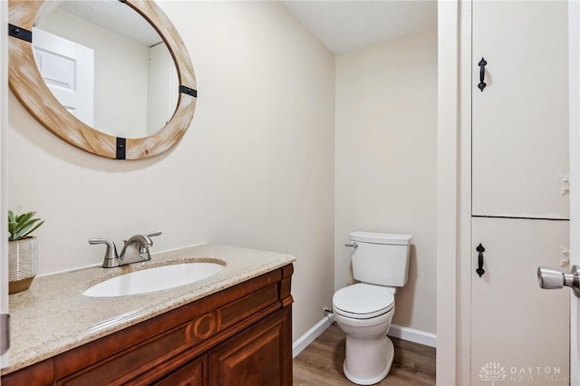 7217 State Route 380, Chester Twp, OH 45177 - half bath with vanity, toilet, wood finished floors, and baseboards