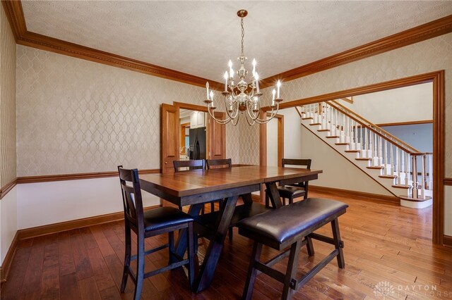1656 Fox Trl, Bellbrook, OH 45305 - dining area with wallpapered walls, stairway, hardwood / wood-style floors, a chandelier, and baseboards