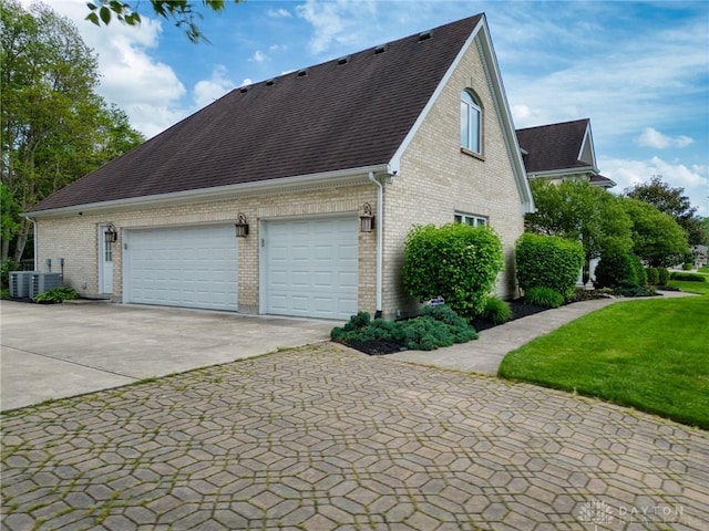 1656 Fox Trl, Bellbrook, OH 45305 - view of side of home with driveway, brick siding, an attached garage, a shingled roof, and central AC unit