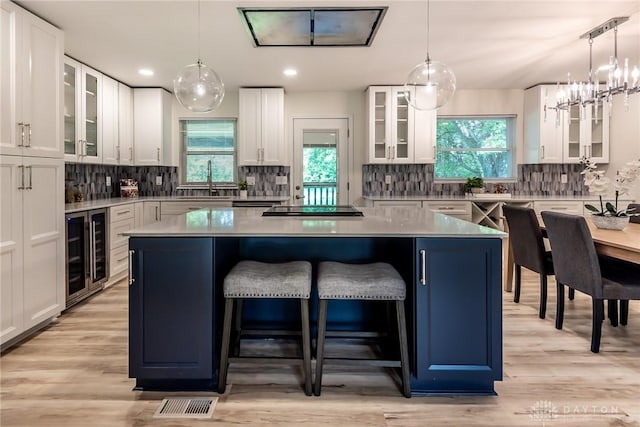 6399 Kimberly Dr, Fairfield Twp, OH 45011 - kitchen with beverage cooler, a center island, decorative backsplash, black electric cooktop, and recessed lighting
