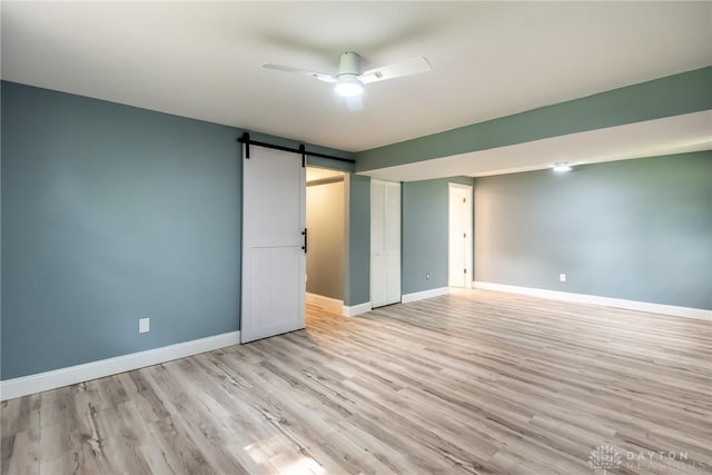6399 Kimberly Dr, Fairfield Twp, OH 45011 - unfurnished bedroom featuring wood finished floors, baseboards, a barn door, and a ceiling fan