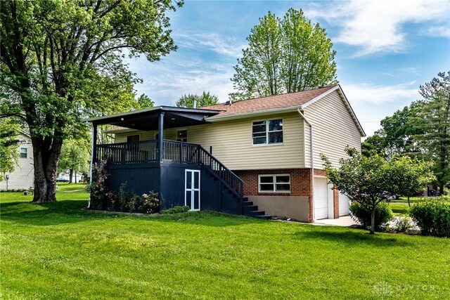 6399 Kimberly Dr, Fairfield Twp, OH 45011 - rear view of house with stairs, an attached garage, a lawn, and brick siding