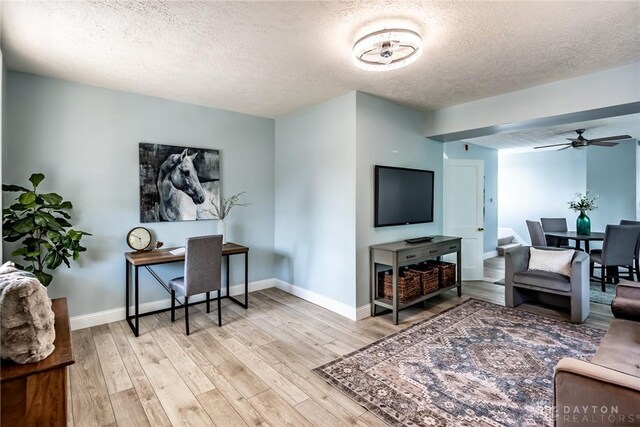 919 Summer St, Hamilton, OH 45013 - living area featuring a textured ceiling, light wood finished floors, a ceiling fan, and baseboards