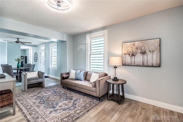919 Summer St, Hamilton, OH 45013 - living area with baseboards, wood finished floors, healthy amount of natural light, a ceiling fan, and a textured ceiling