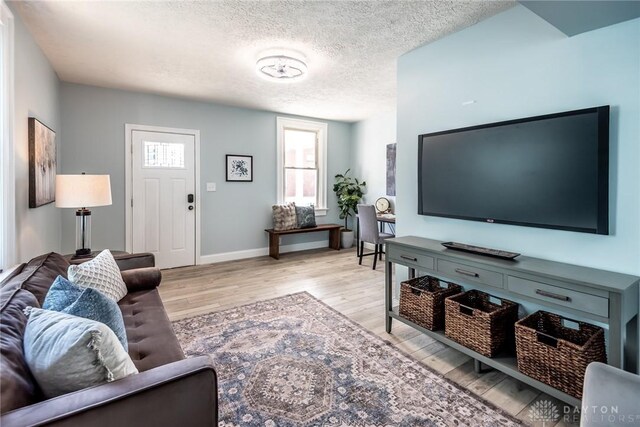 919 Summer St, Hamilton, OH 45013 - living area with light wood-style floors, baseboards, and a textured ceiling