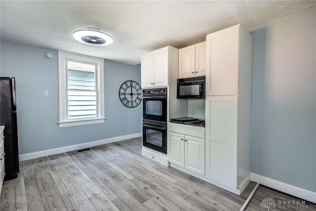 919 Summer St, Hamilton, OH 45013 - kitchen featuring black appliances, baseboards, light wood-type flooring, and white cabinets